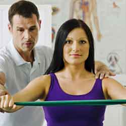 Man helping a woman with physiotherapy services.